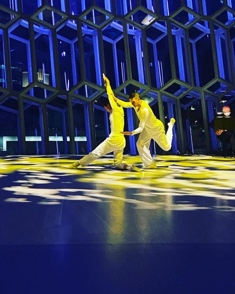 Dancers wearing white performing Are we Ok?  in yellow light
