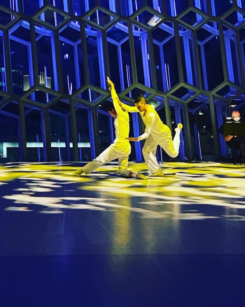 Dancers wearing white performing Are we Ok? in yellow light