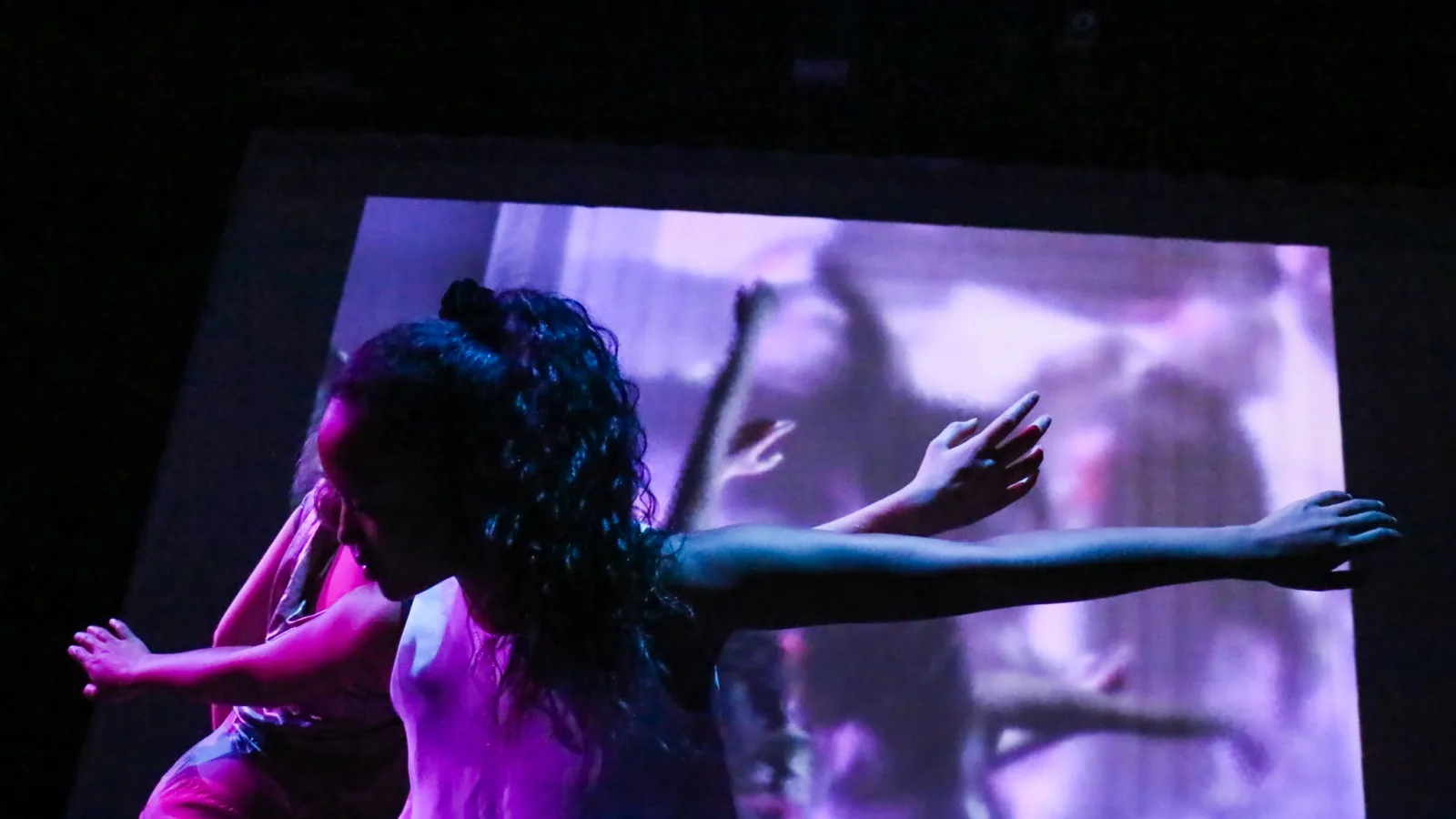 Dancers performing in front of video screen