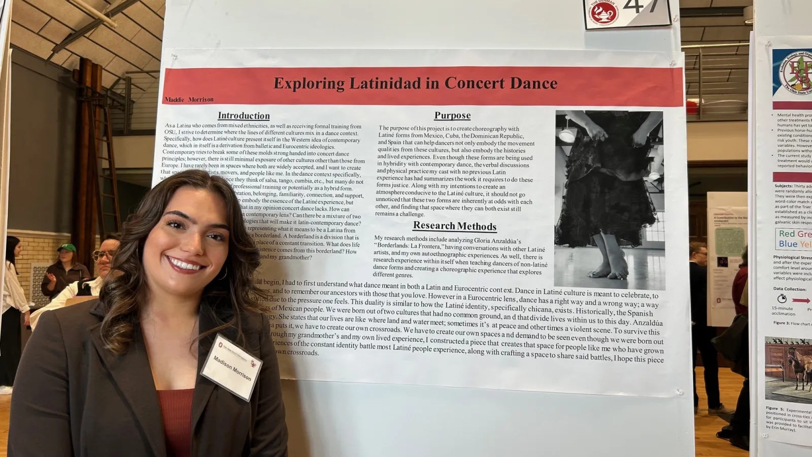 Student posing with research poster.