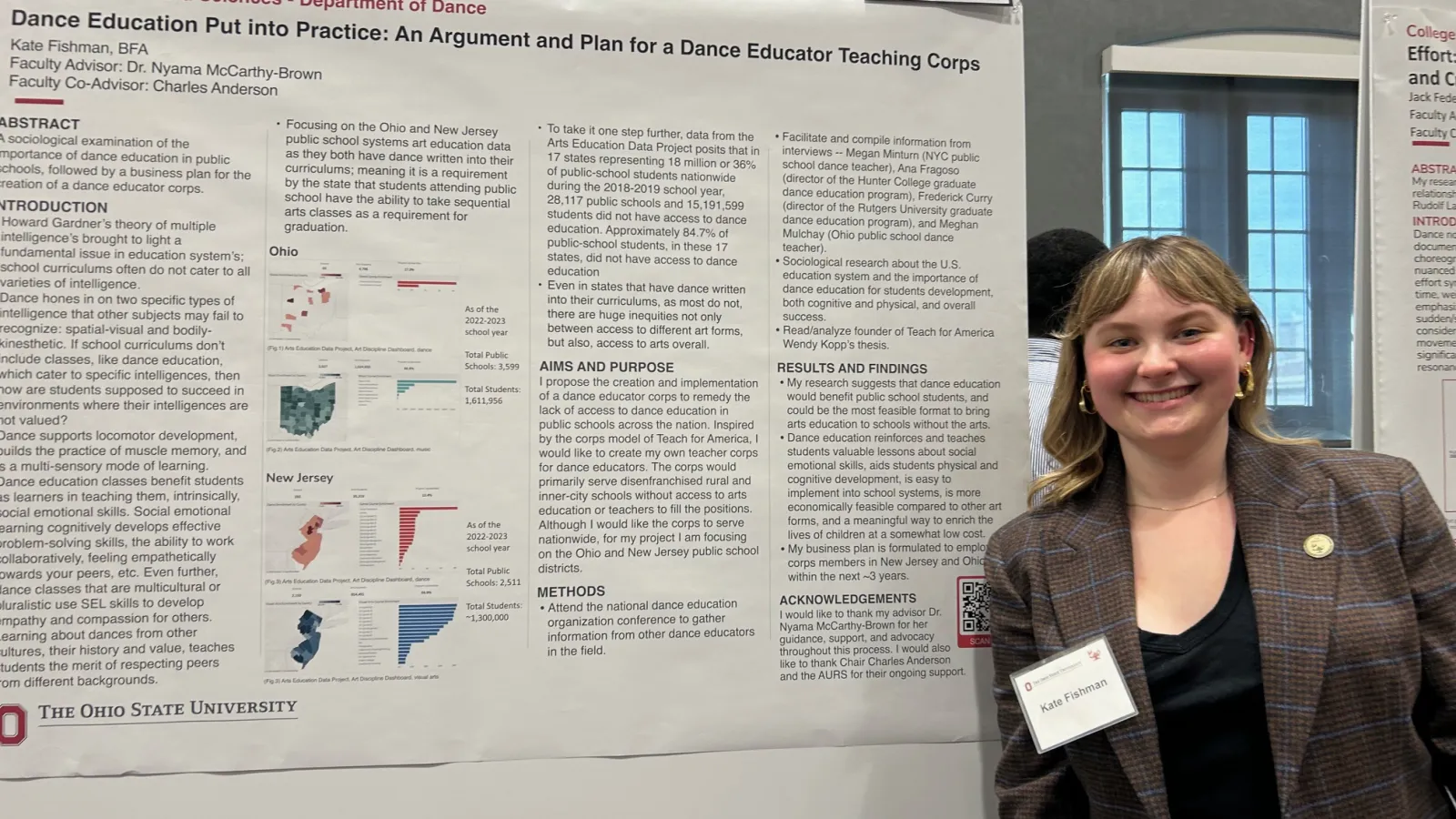 Student posing with research poster.