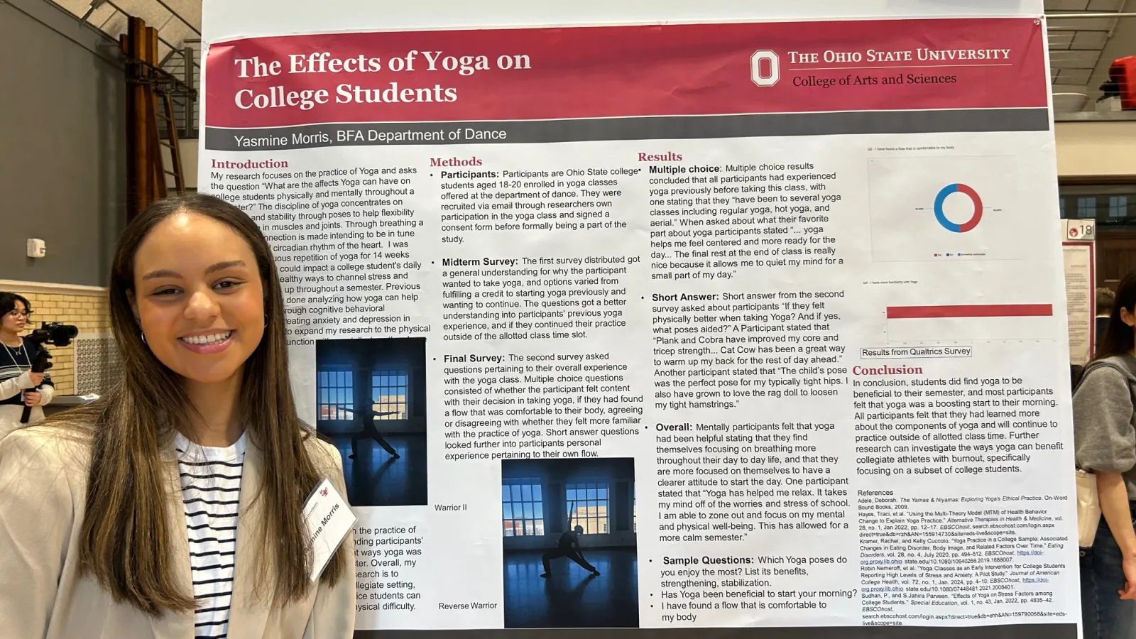Student posing with research poster.