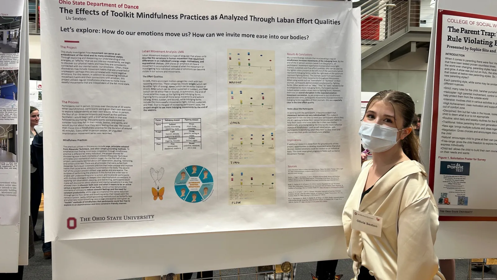 Student posing with research poster.