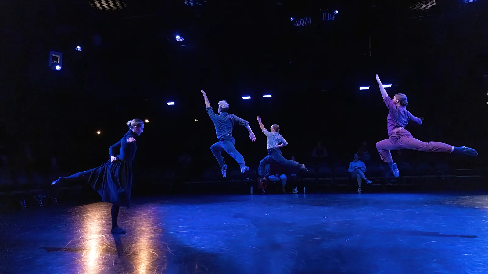 dancers in earth tone costumes on a stage