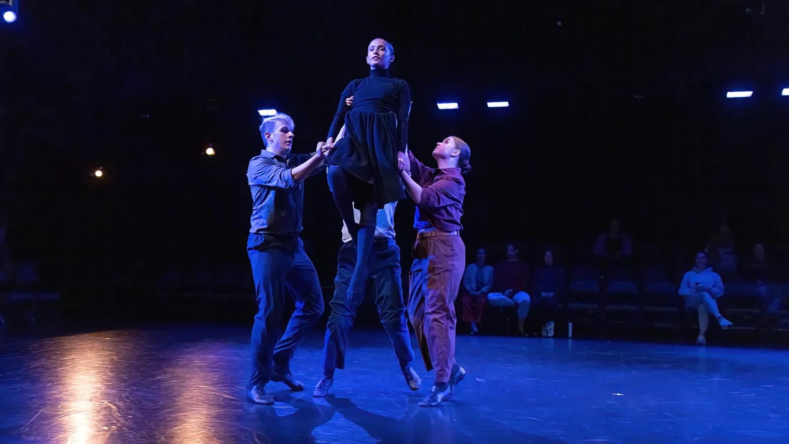 dancers in earth tone costumes on a stage