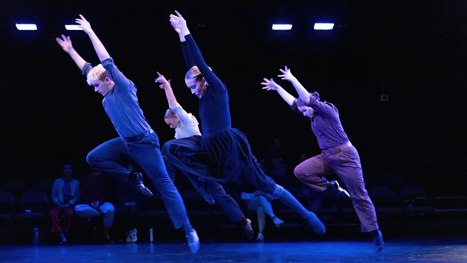 dancers in earth tone costumes on a stage
