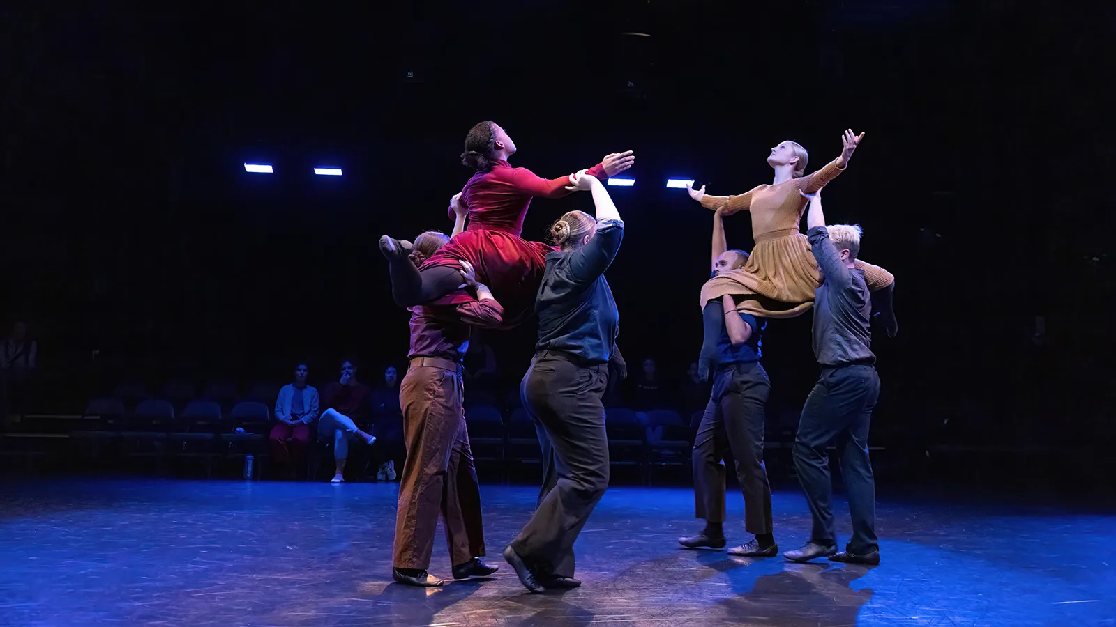 dancers in earth tone costumes on a stage