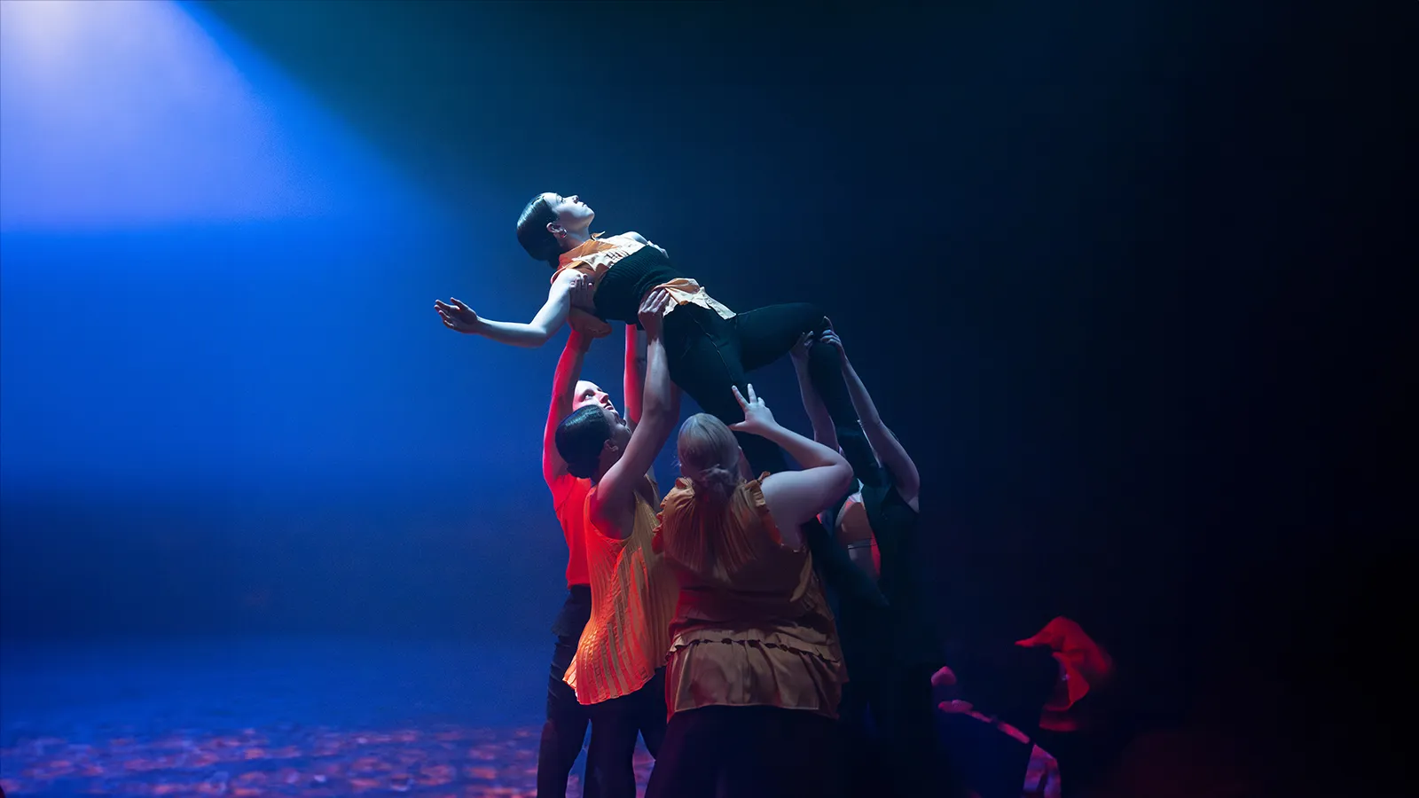 Four people lifting a person