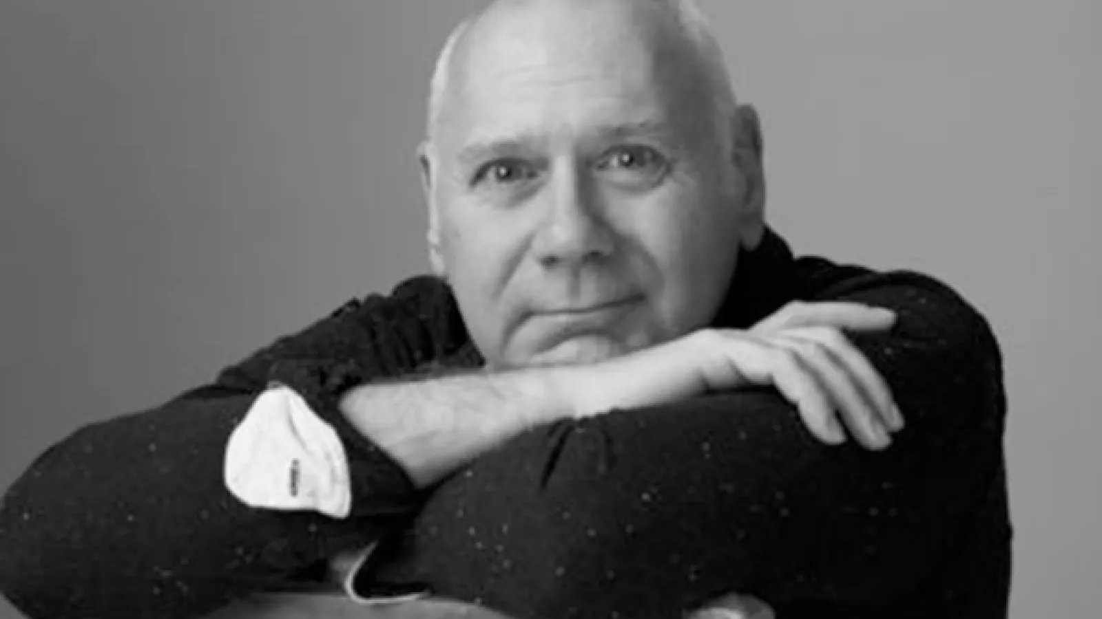 Man sitting in a chair with arms folded