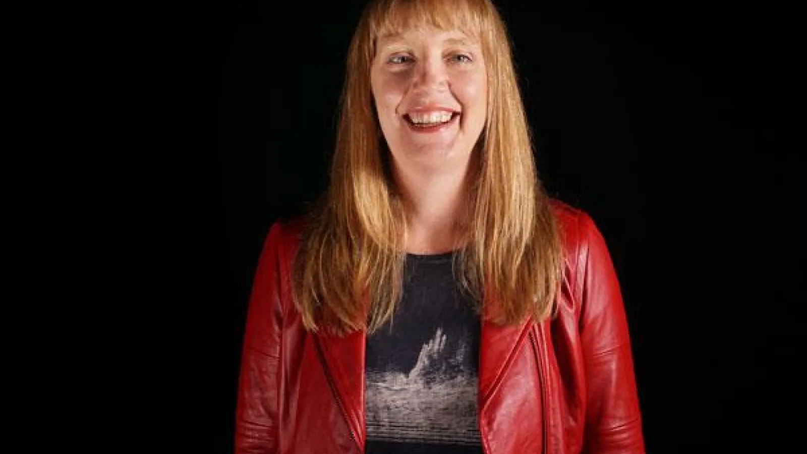 person with long red hair wearing red jacket