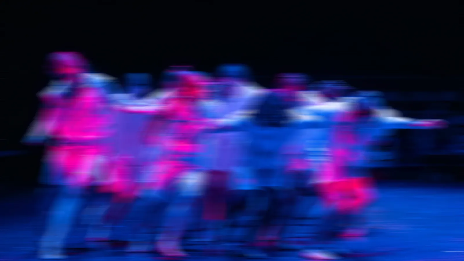 blurred image of dancers performing on a stage