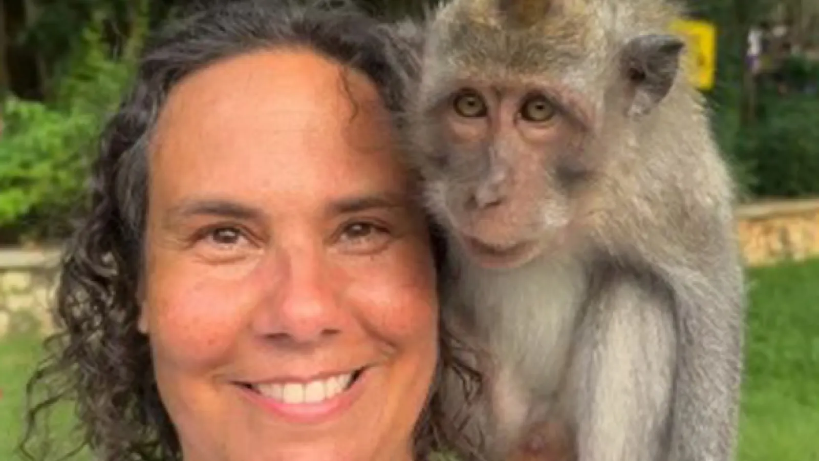 Person with brown hair with monkey on shoulder