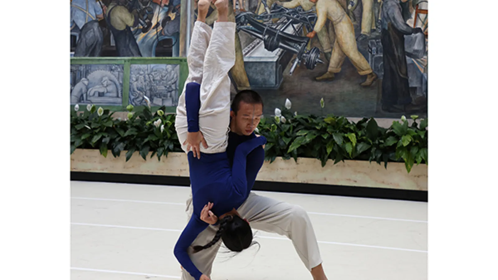 Dancers performing in front of a mural
