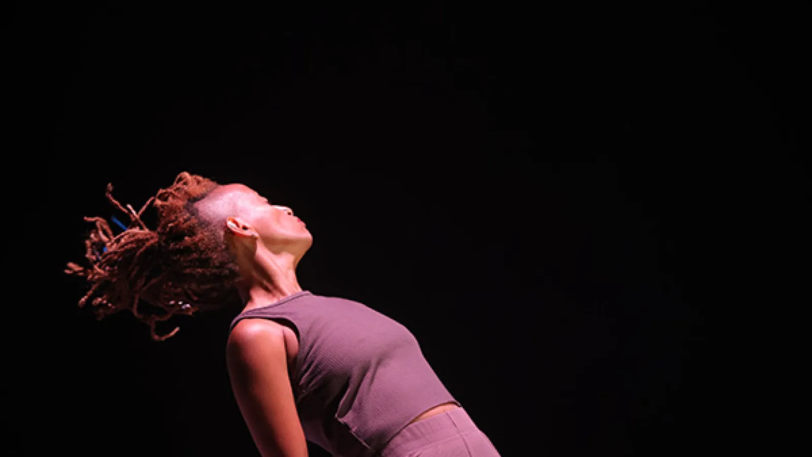 A woman hinges backward, powerfully.