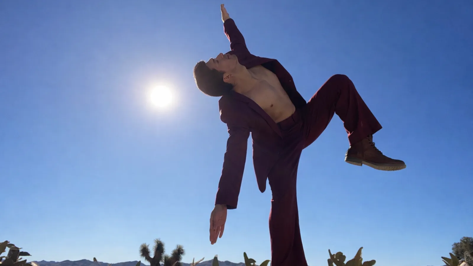 a person dancing with sun and blue sky in background