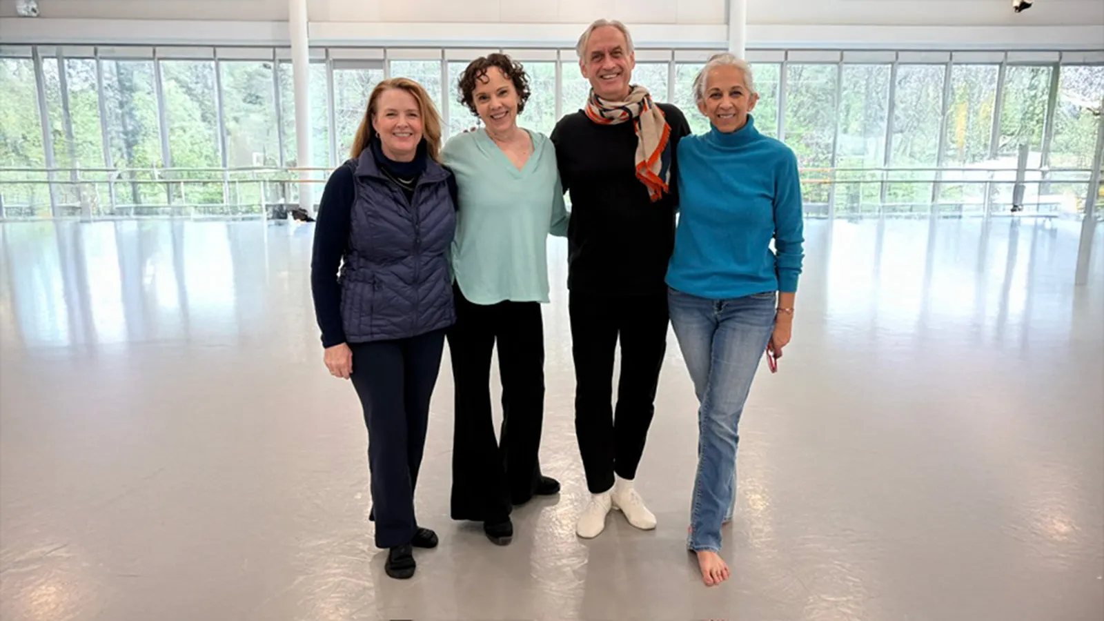 People standing in a dance studio with a large window in the background