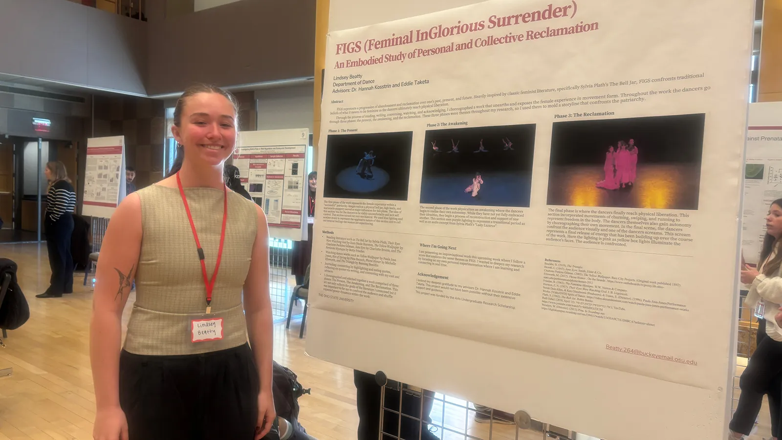 A woman smiling and standing next to a research poster