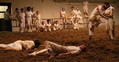Our Town, an original work by Bebe Miller, a dirt covered stage filled with dancers.