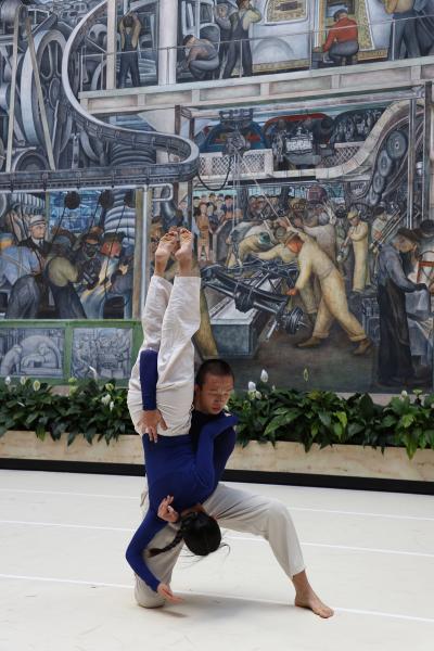 Dancers performing in front of a mural