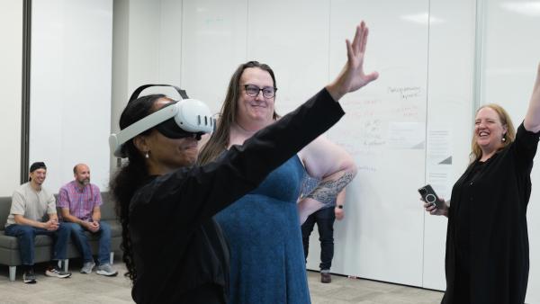 Dancer wearing virtual reality headset next to instructors