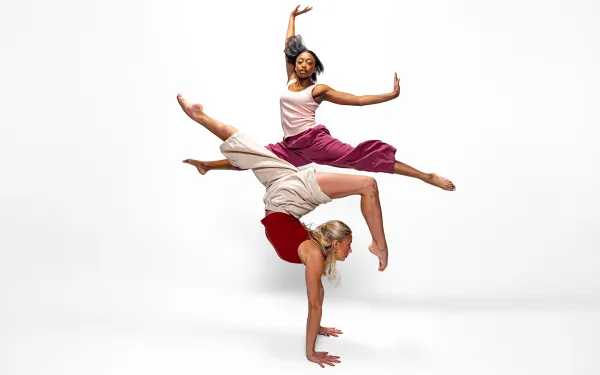 Two dancers performing in front of a white background
