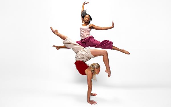 Two dancers performing in front of a white background
