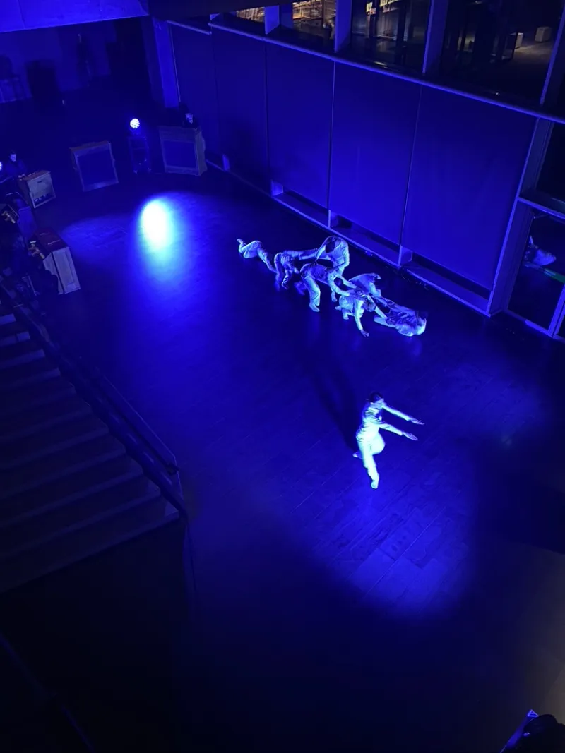 Dancers wearing white performing Are we Ok? in blue light