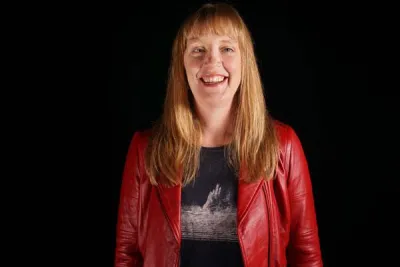 person with long red hair wearing red jacket