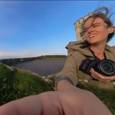 person smiling with blue sky in background