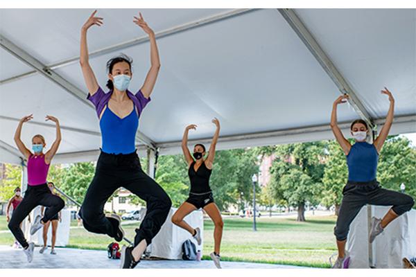 Dancers practice movement in one of the arts tents
