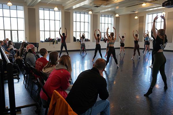 Dancers rehearsing in a studio with audience