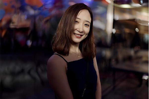 person with long black hair smiling