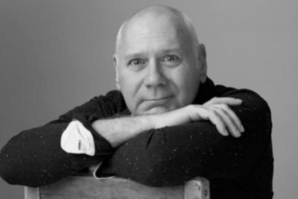 Man sitting in a chair with arms folded