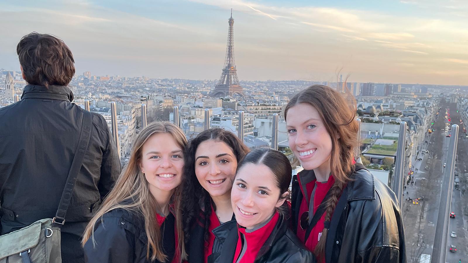 Women posing with Paris in the background 
