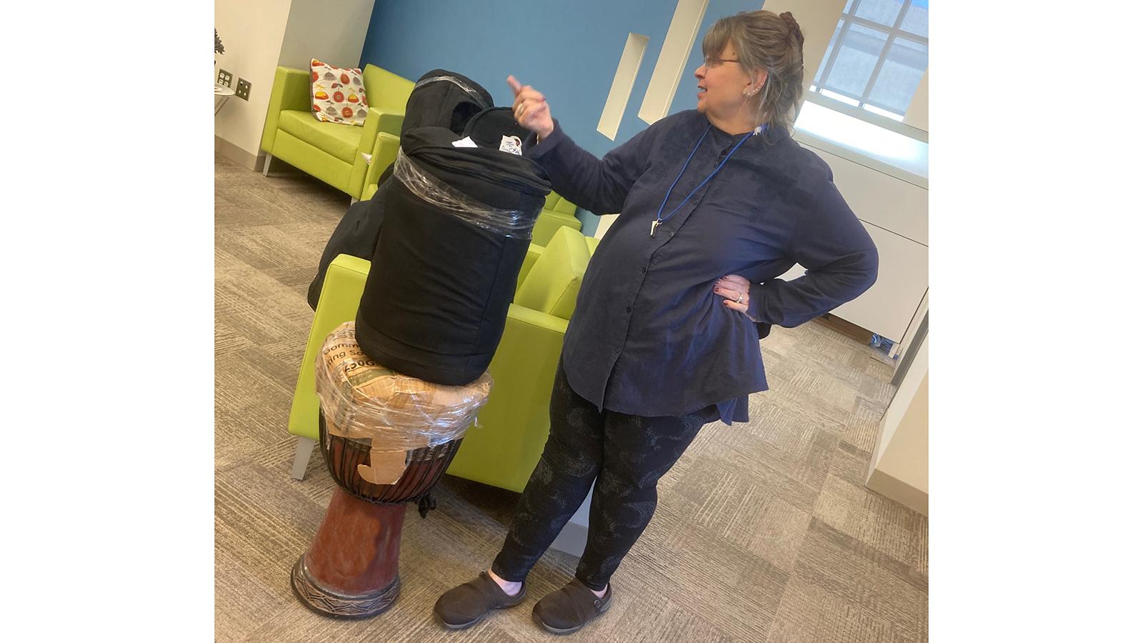 Woman standing next to African drum