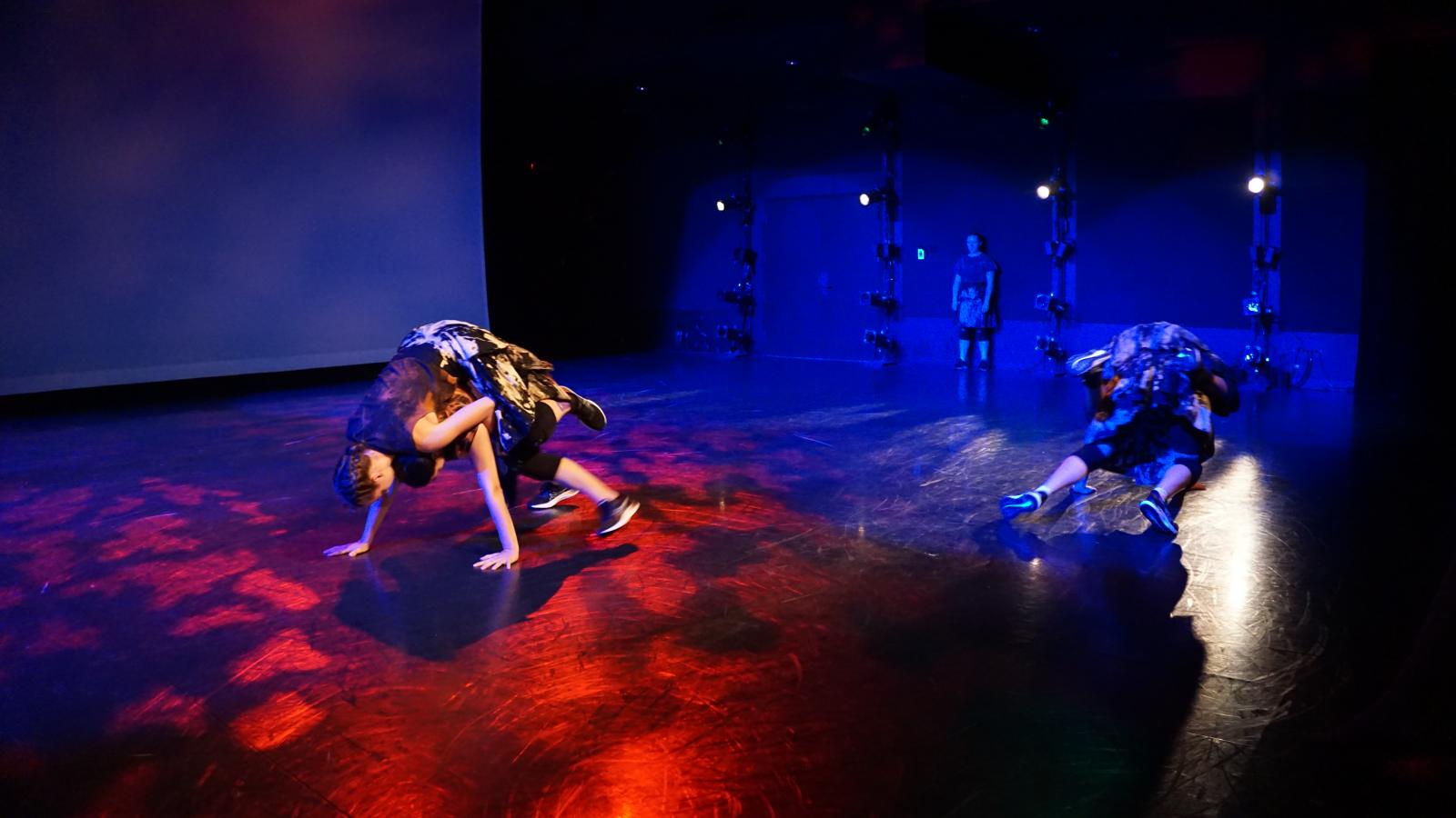Dancers rolling on black floor 