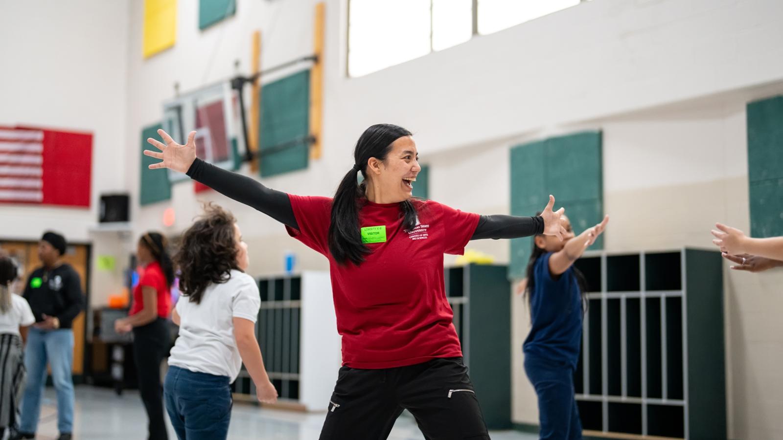 Dancer teaching students in a gym