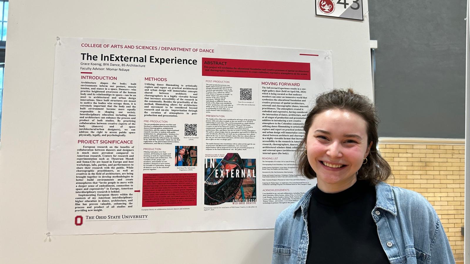 Student posing with research poster.