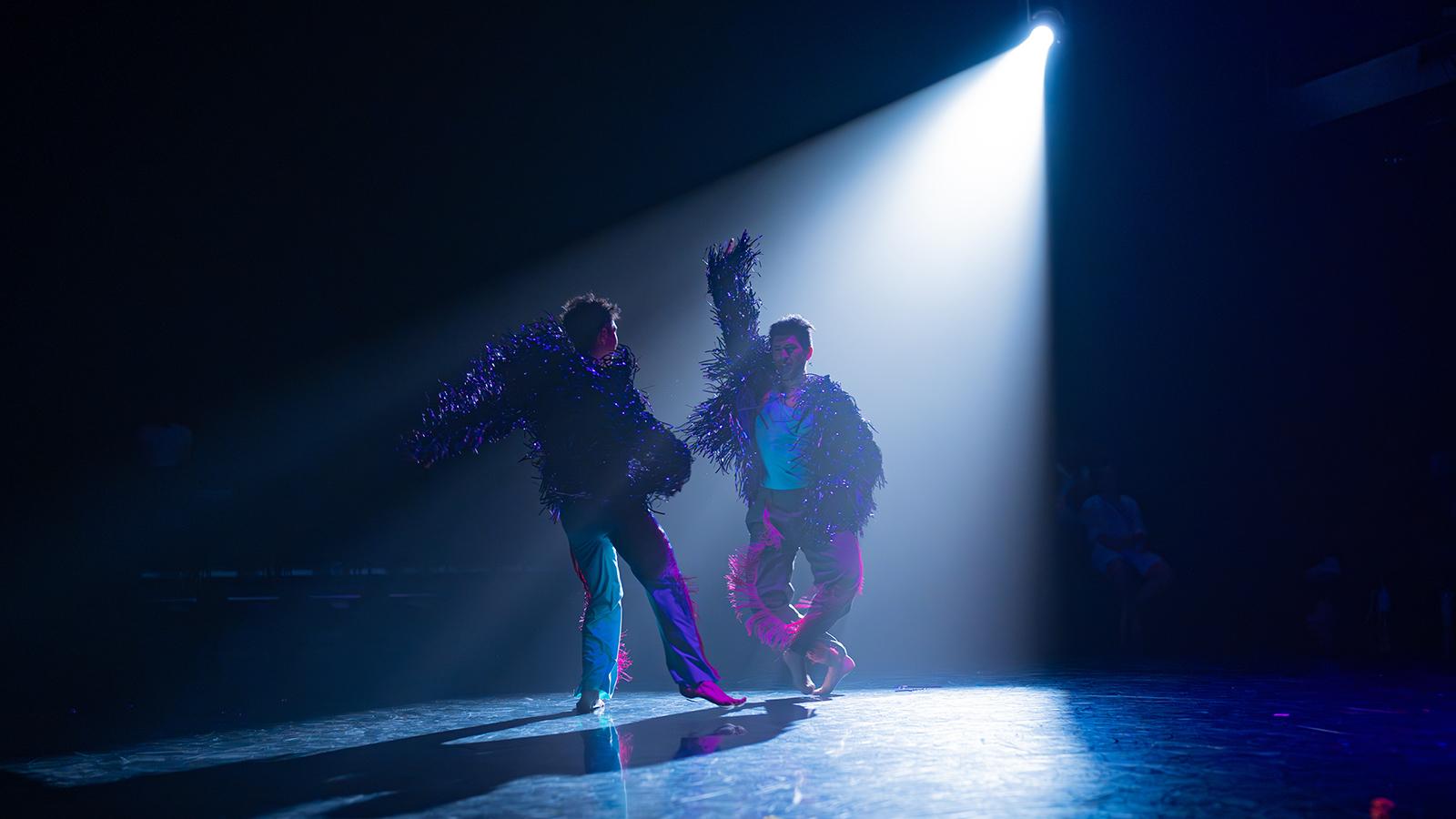 two people dancing under one white light