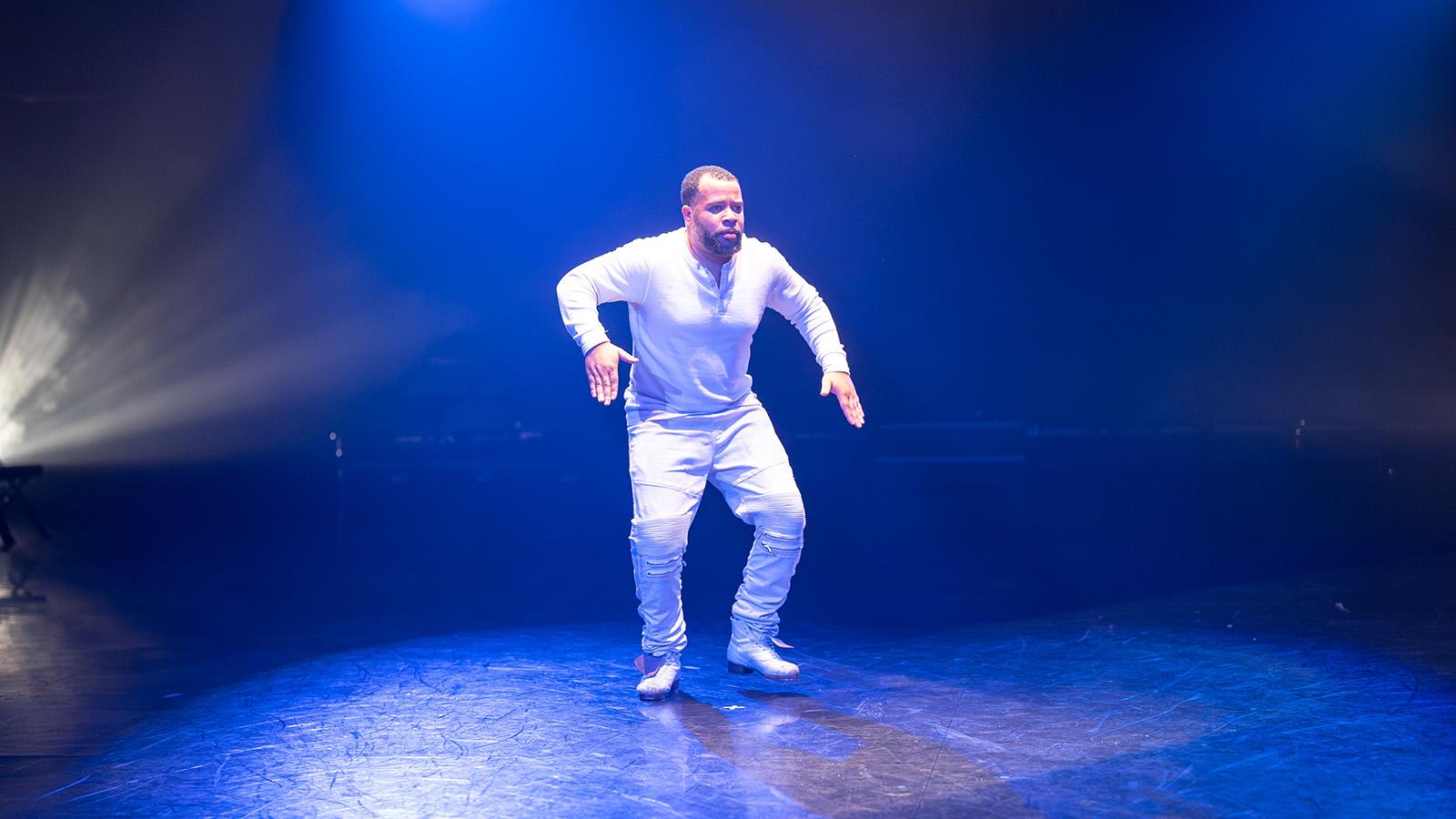 person dressed in white on lit stage