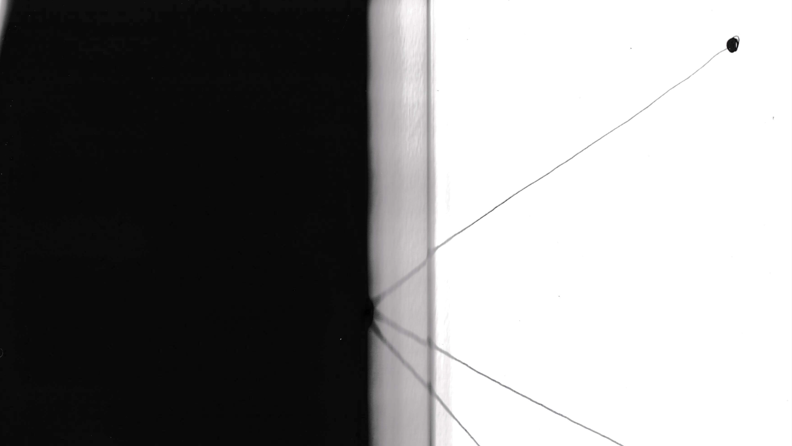 A black and white image, half of the frame is filled with black and the other is white with thin lines drawn out from the center.