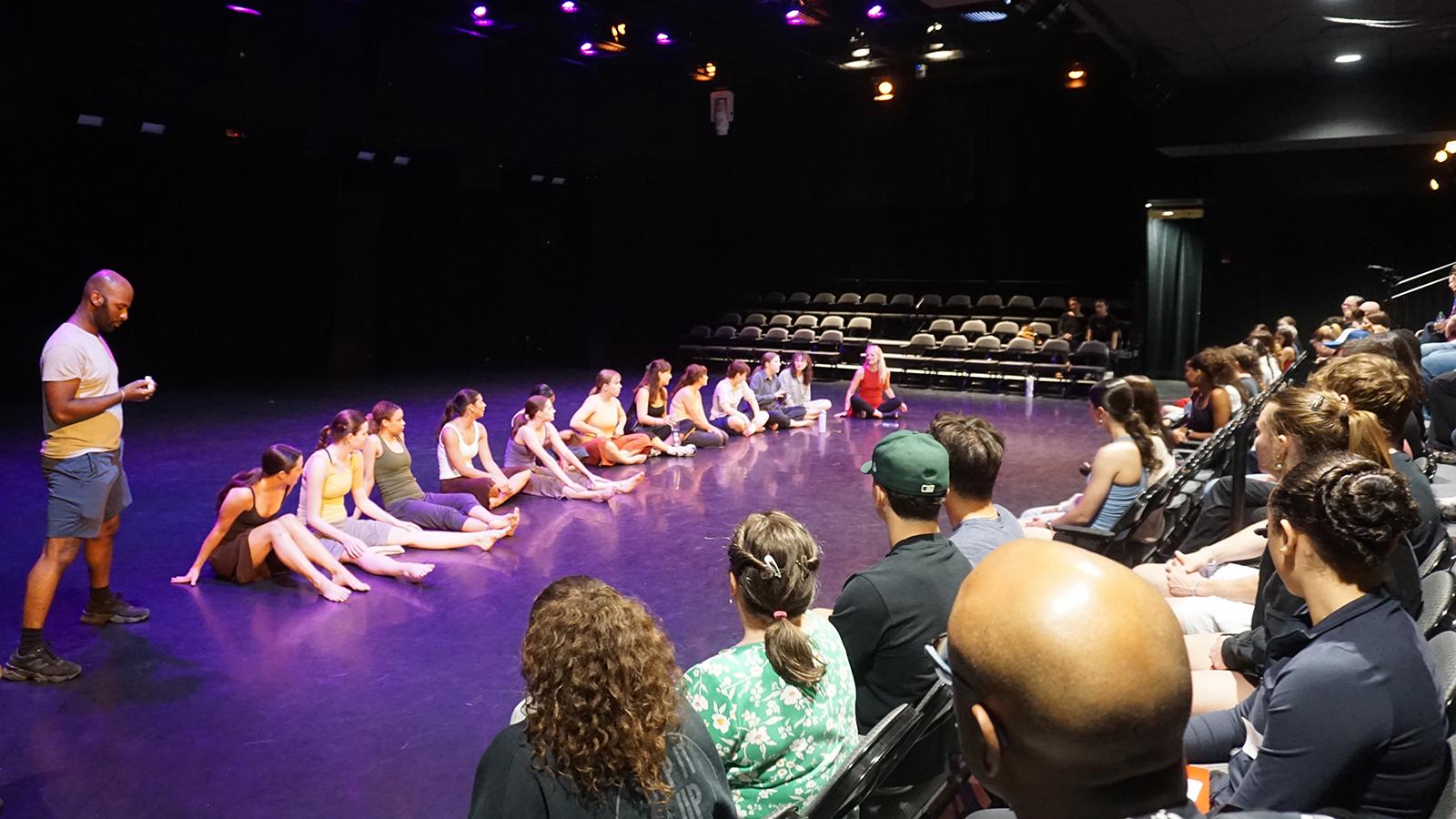 Dancers on a stage talking to an audience