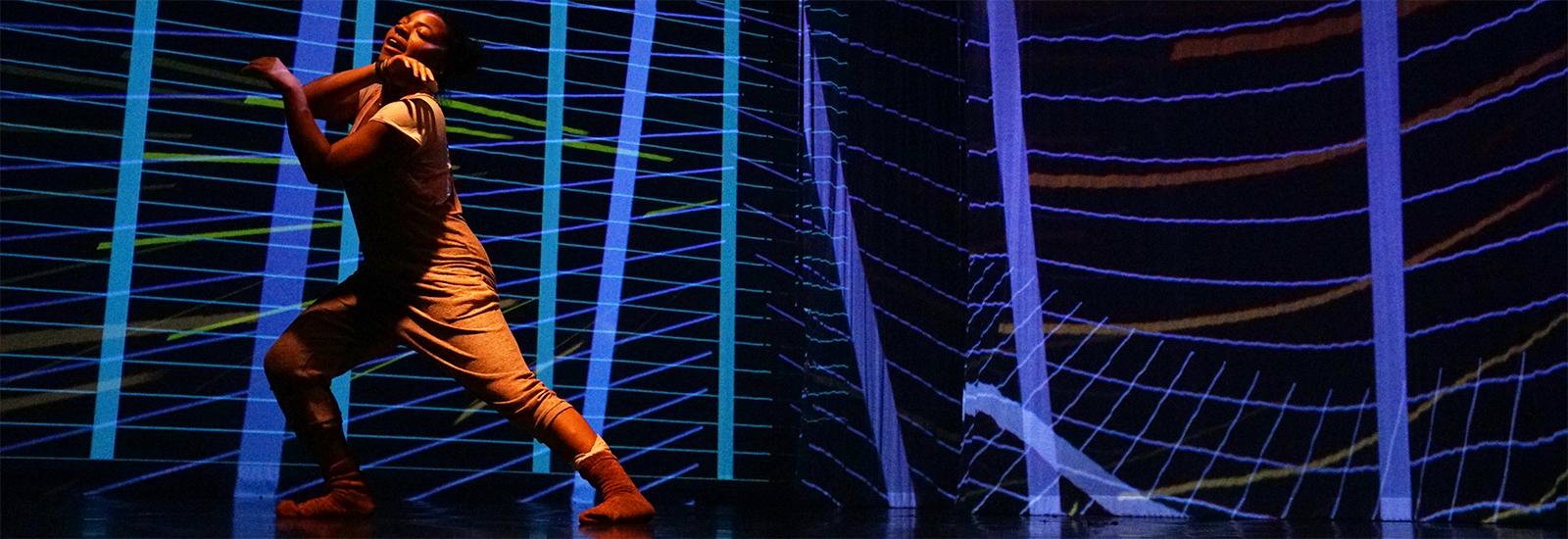 Dancer dancing behind black background with light waves