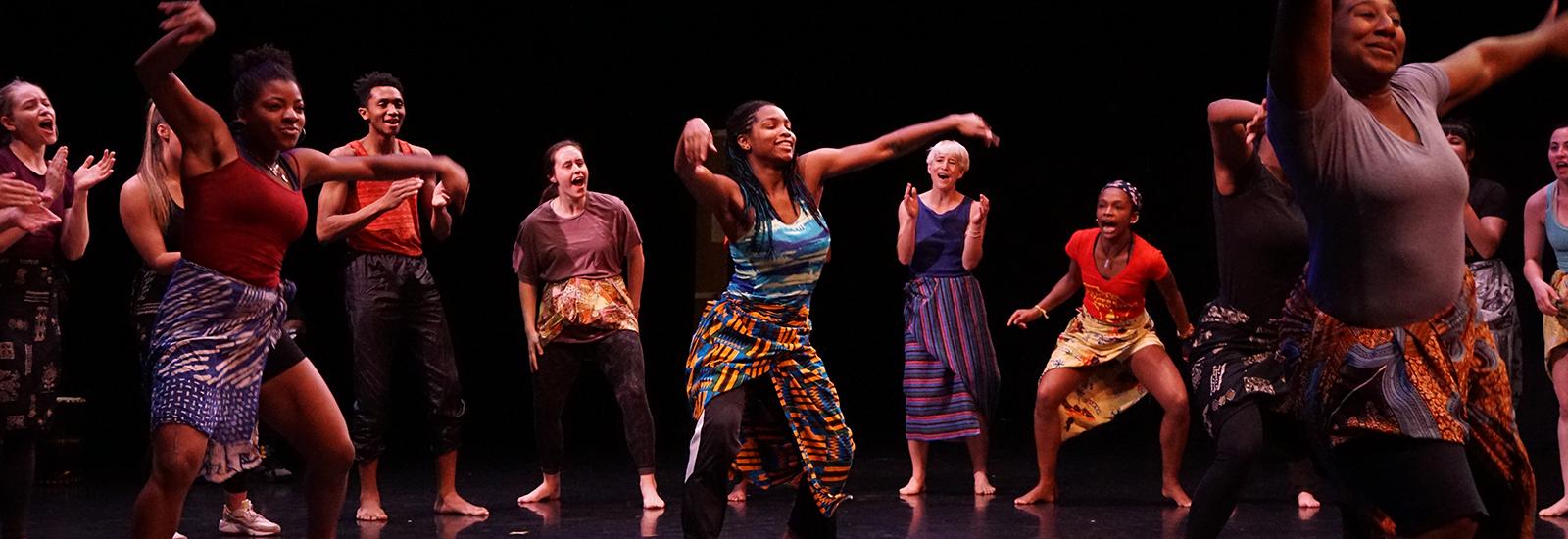 Dancers performing African Diasporic dance on a stage
