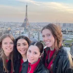 Women posing with Paris in the background 